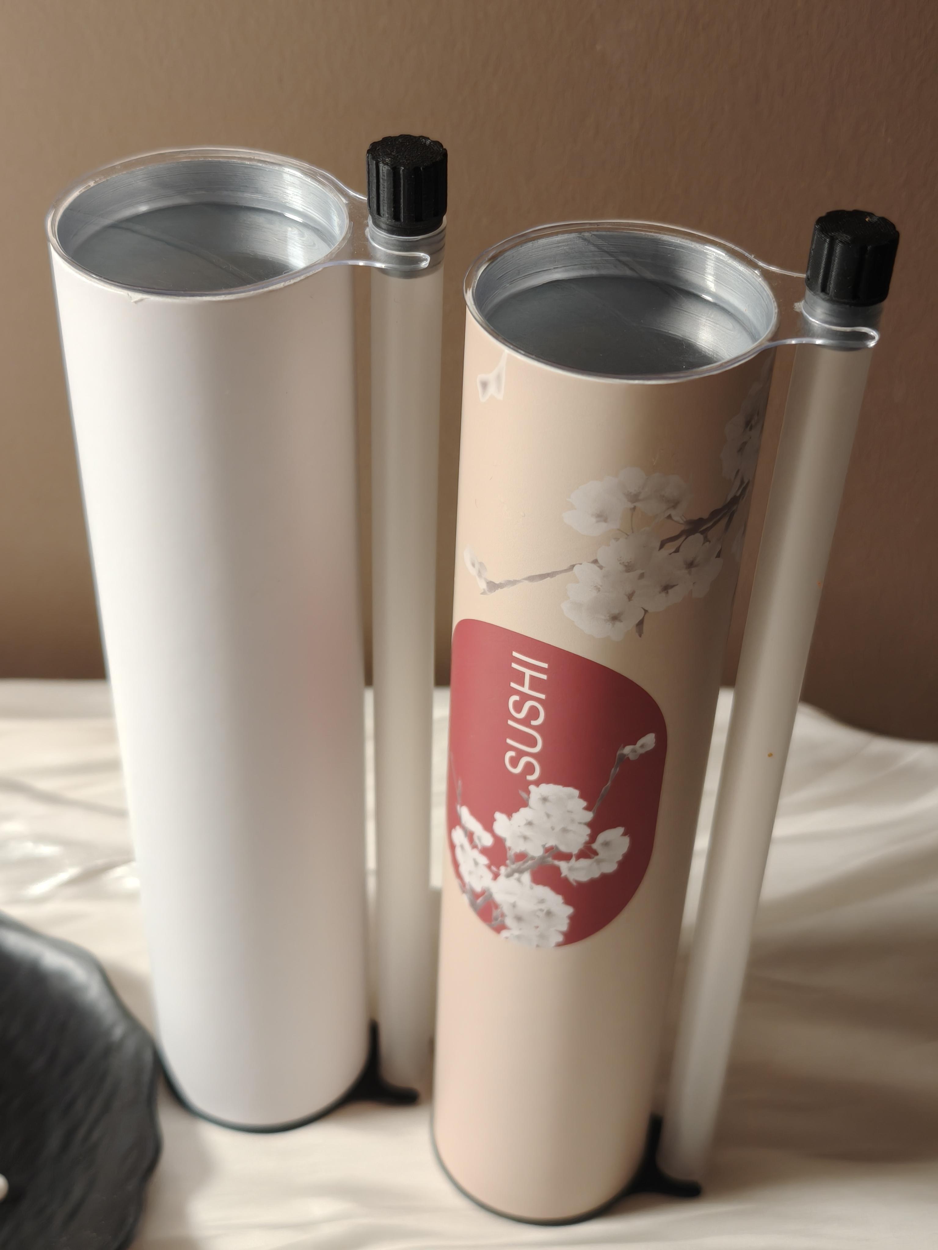 Company-supplied photograph of two open push sushi tube samples showing the cylindrical body, inner lining, movable base and external sauce vial